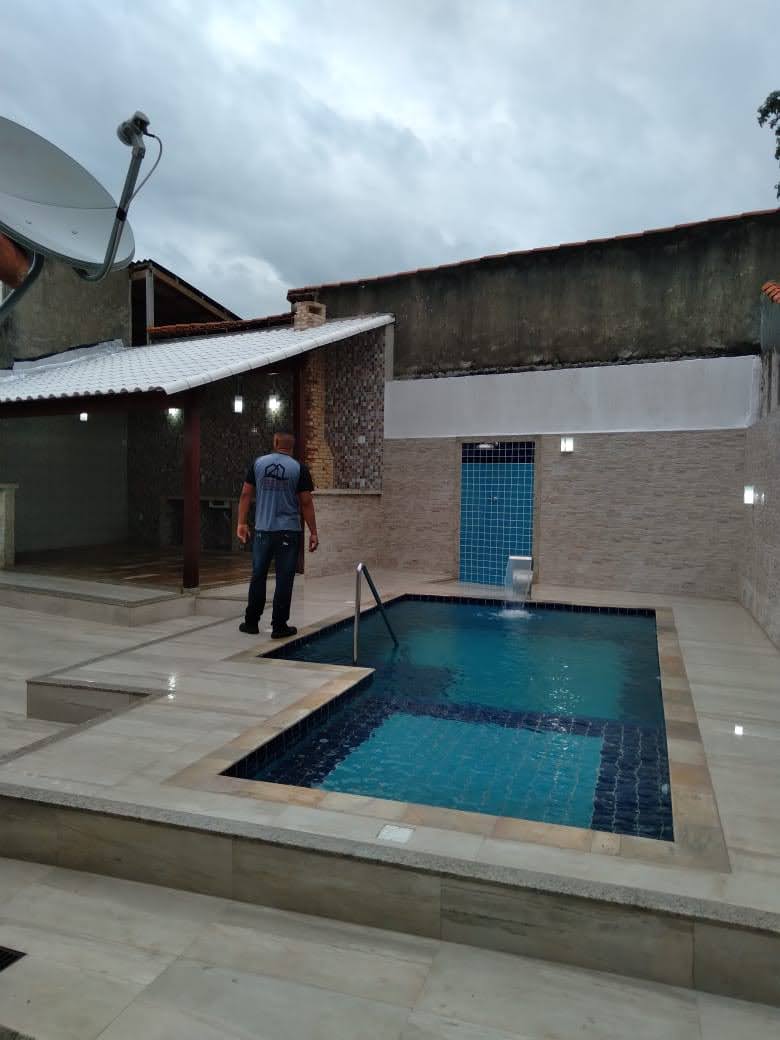 Piscina finalizada com cascata e área gourmet coberta