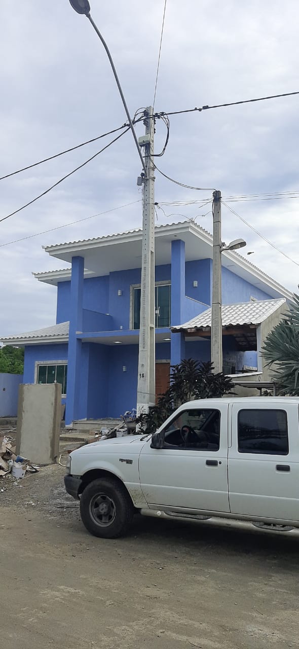 Sobrado azul de dois pavimentos com varanda e colunas