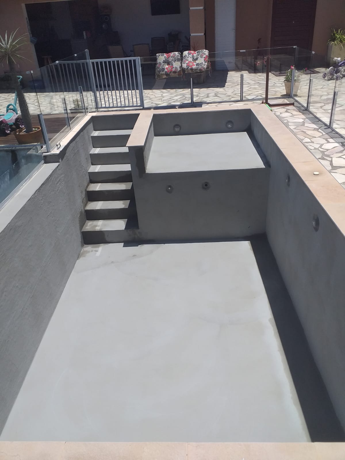 Piscina em concreto com escada e iluminação embutida