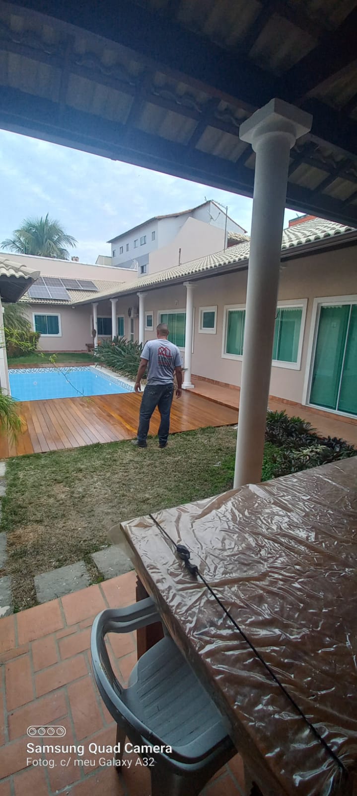 Área de lazer com piscina, deck amadeirado e energia solar